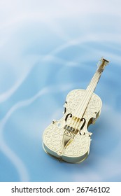 Golden violin on rippled water background