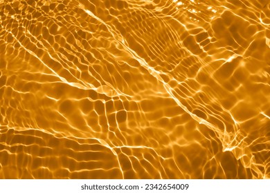 Golden water with ripples on the surface. Defocus blurred transparent gold colored clear calm water surface texture with splashes and bubbles. Water waves with shining pattern texture background. - Powered by Shutterstock