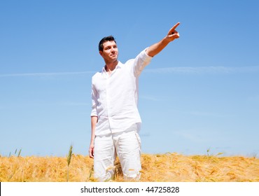 Golden Wheat Field Standing Man With Hands Up Showing The Way Forward As Symbol Concept For A Better Business Career