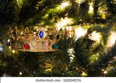 A Golden Wizard King Crown With Colored Gems, Among The Branches Of A Christmas Tree Illuminated By Its Christmas Lights.