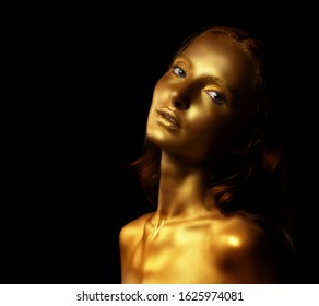 Golden woman. Beauty fashion model girl with golden skin, makeup, hair black background. Fashion art portrait. beautiful collarbone and the shoulders are shiny