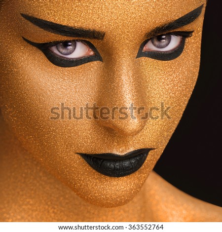Golden Woman's Face Close up. Futuristic Gilded Make-up. Painted Skin