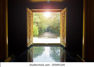 Golden wooden door open to nature in the garden with sunrise.