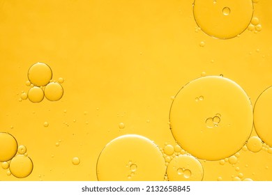 Golden yellow abstract oil bubbles or face serum background. Oil and water bubbles macro photography. - Shutterstock ID 2132658845