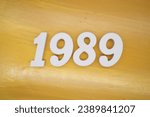 The golden yellow painted wood panel for the background, number 1989, is made from white painted wood.