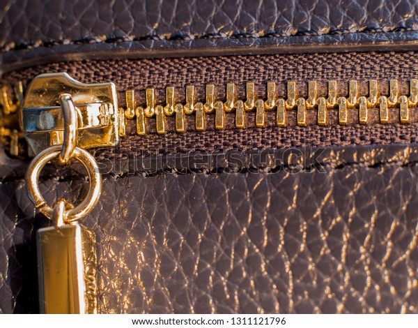 a golden zipper of a\
leather bag