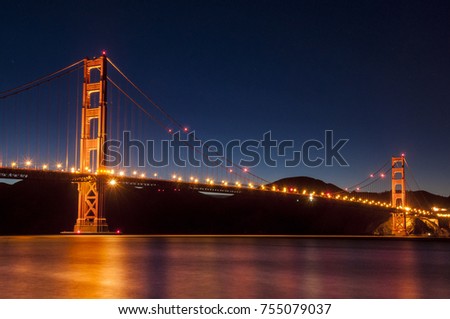 GoldenGate Bridge San Francisco at night with reflections in water
