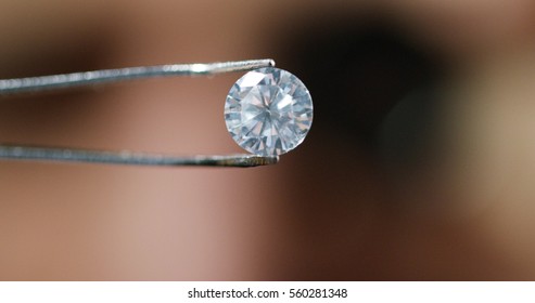 A goldsmith in jewelry checks the quality of luxury brilliant diamonds. The diamonds of high caliber shine the light and pure. Concept: Jewelry, luxury, glitz, gloss and goldsmith.