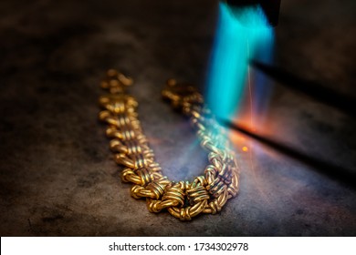 Goldsmith makes gold necklace, use high fire blow soften the gold for easy formatting,which tradition method.