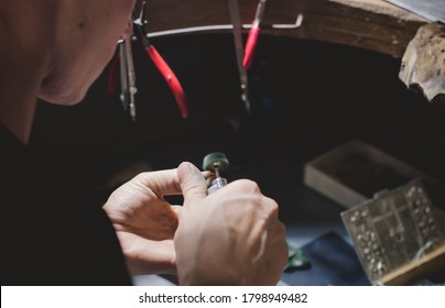 Goldsmith making a ring at her work shop using tools. Close up of hands of jewelry maker using polishing machine. - Shutterstock ID 1798949482