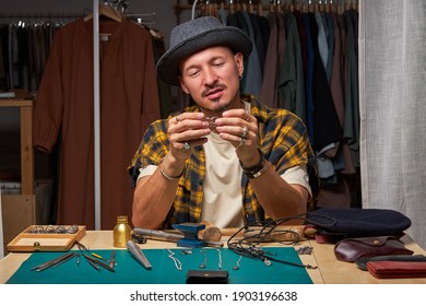 goldsmith man looking at handmade rings, successful work in workshop, making jewelry