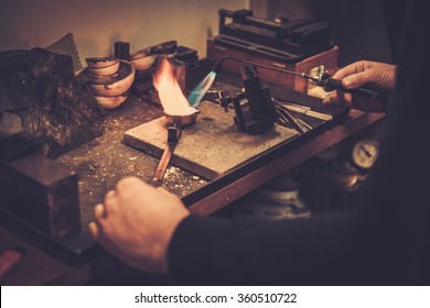 Goldsmith melting gold to liquid state in crucible with gasoline burner. - Powered by Shutterstock