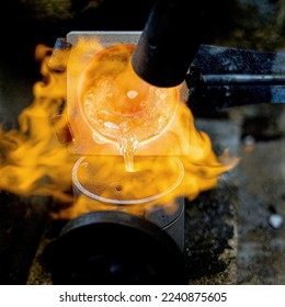 Goldsmith melting silver and gold with a blowtorch and pouring it in a mold to make wedding or engagement rings - Powered by Shutterstock