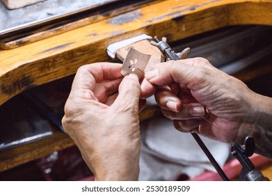 Goldsmith working on a jewel on his workbench - Powered by Shutterstock