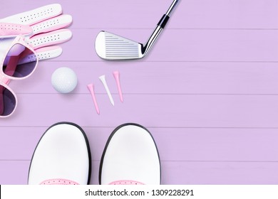 Golf accessories for women on a wooden surface in purple from above in a modern look