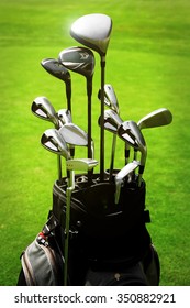 Golf Bag With Clubs On Green Field, Close Up