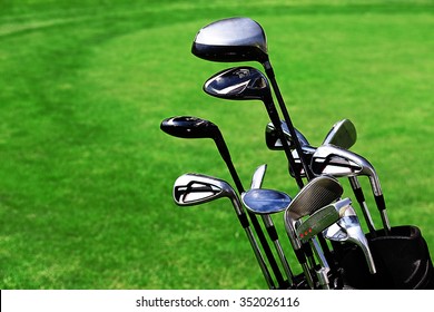 Golf Bag With Clubs On Green Field, Close Up