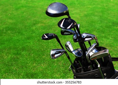 Golf Bag With Clubs On Green Field, Close Up