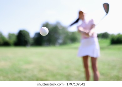 Golf ball against background of hitting woman closeup. Active healthy lifestyle concept - Powered by Shutterstock