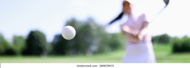 Golf ball against background of hitting woman closeup. Active healthy lifestyle concept - Powered by Shutterstock