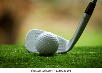 Golf ball and golf club in beautiful golf course at Thailand. Collection of golf equipment resting on green grass with green background