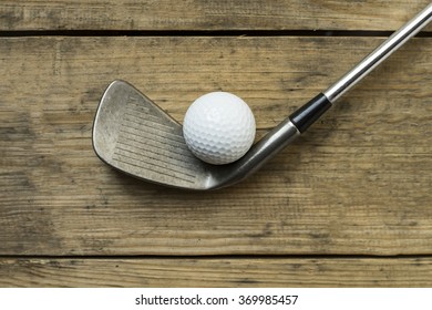 Golf Ball And Golf Club On Old Wood Table