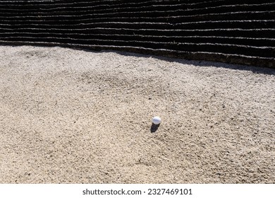Golf ball in a freshly groomed sand trap, recreation and challenge on a sunny summer day
					