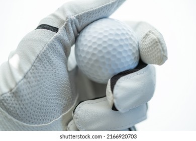 Golf Ball In Hand Of A Player. Sportsman Wearing Golf Glove On His Hand. Close Up.