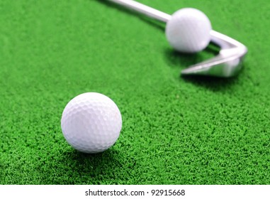 Golf Ball And Iron Golf Club On Green Fake Grass