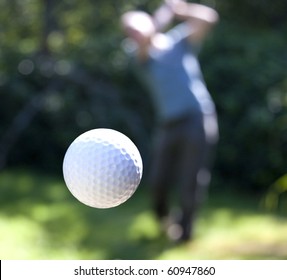 A Golf Ball Just Coming Off The Tee From A Golfer In Swing.