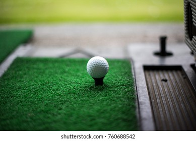 Golf ball on artificial green grass place with tee for practice Driving Range. Select focus - Powered by Shutterstock