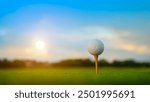 Golf ball on green grass in the evening golf course with sunshine background. Close-up golf ball on tee with blur green bokeh background.                               