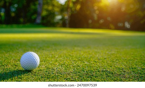 Golf ball is on a green lawn in a beautiful golf course with morning sunshine. Ready for golf in the first short.                                - Powered by Shutterstock