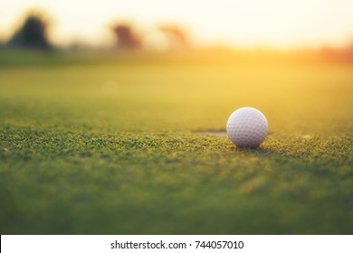 Golf Ball On The Green With Warm Tone And Sunset