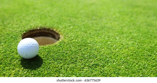 Golf Ball On Lip Of Cup Close Up