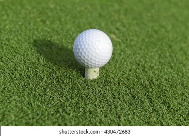 Golf ball on rubber golf tee in teebox
