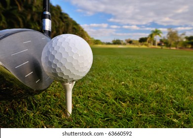 Golf Ball On Tee With Driver Club Ready With Morning Dewy Grass