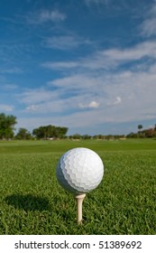 Golf Ball On Tee With Fair Skies Overhead