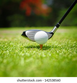 Golf Ball On Tee In Front Of Driver