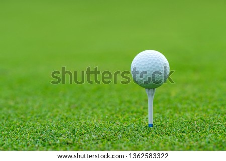 Golf ball on tee ready to be shot at golf court.
