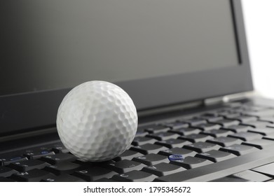 A Golf Ball On Top Of A Laptop To Make A Descision Of Work Or Play.