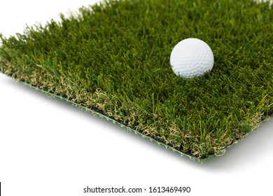 Golf Ball Resting On Section Of Artificial Turf Grass On White Background.