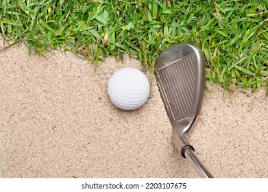 A Golf Ball In A Sand Trap Getting Ready To Be Hit With An Iron.