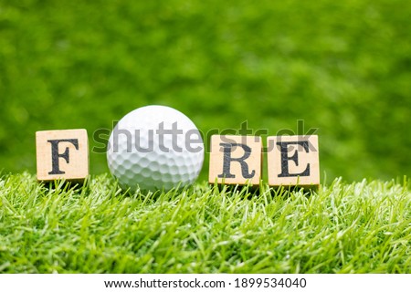 Golf ball with word FORE is on green grass background