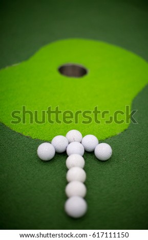 Golf Balls in Arrow Pattern Towards Hole. Goal. Win.
