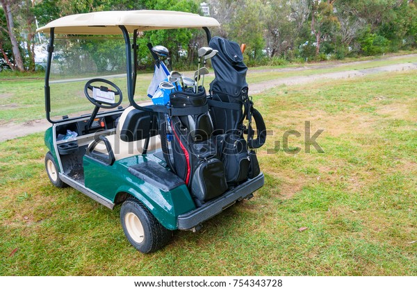 Golf\
car on green lawn of golf course. Golf sport\
scene
