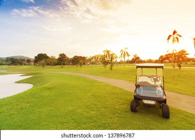 Golf Car With Sun Set In Golf Course.