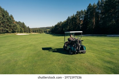 Golf Cart Car In Fairway Of Golf Course With Fresh Green Grass Field And Cloud Sky And Tree On Sunset Time. Golf Is A Sport That Must Be Played On The Lawn.
