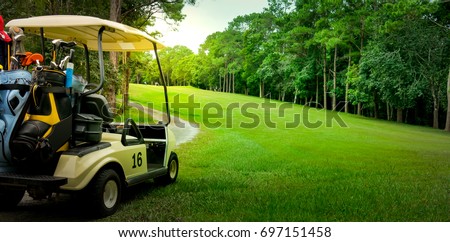 Golf cart or car on golf course. Looking see beautiful layout and fairway. Beautiful Road for cart to drive. Morning sky and cloud. Equipment and bag are put in ready for golfer to player in field