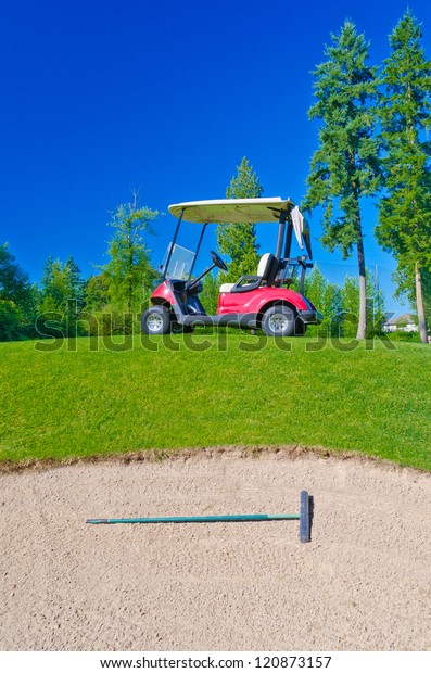 Golf\
cart at the golf course in front of the sand\
bunker